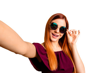 Self-portrait of red straight-haired attractive cute nice cheerful young girl, wearing round sun glasses, having fun. Isolated over bright vivid yellow background