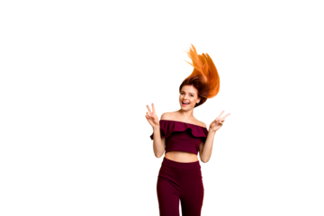 Red straight-haired attractive cute nice cheerful young girl, half turned, wind blowing hair up in air, showing double v-sign. Isolated over bright vivid yellow background