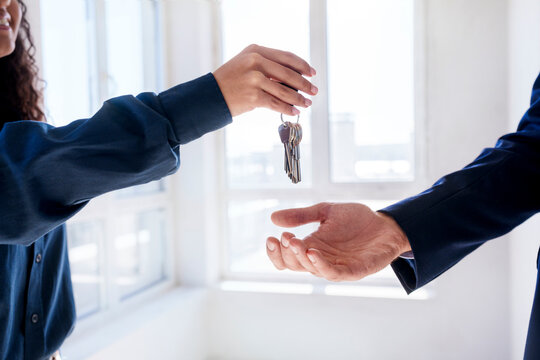 Real estate agent giving keys to new owner of house