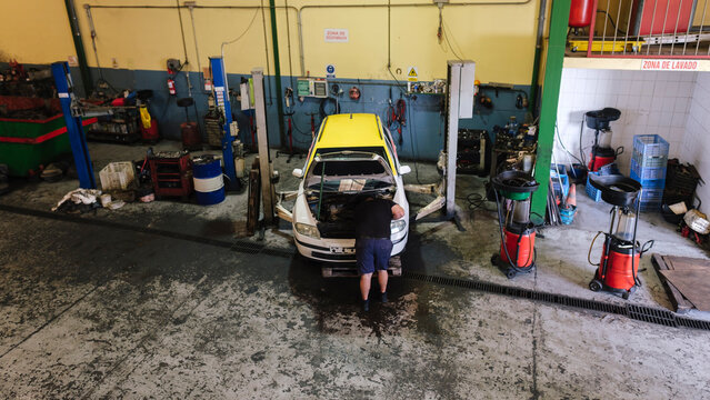 Mechanic working on car engine at workshop