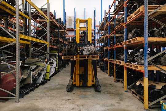 Forklift amidst shelves of vehicle parts at warehouse