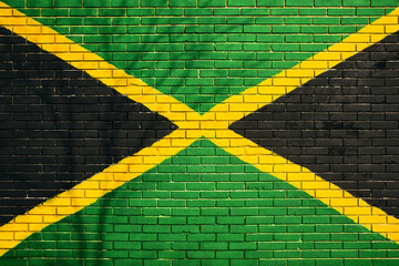 Jamaican flag painted on building brick wall with bare tree shadow cast on the surface