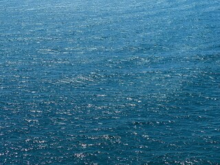 Blue sea water glittering ripples surface. 