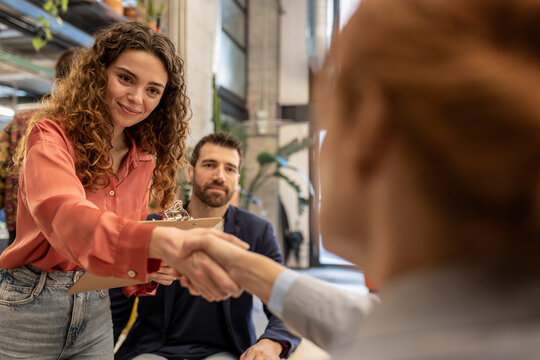 Smiling recruiter doing handshake with candidate at office