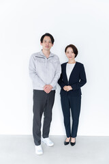 作業着を着た男性とスーツを着た女性