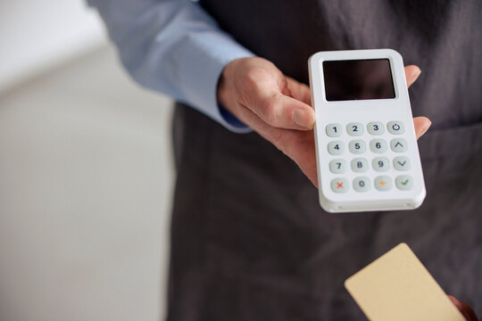 Engineer holding credit card reader in hand at workshop