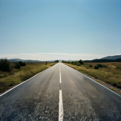 Fototapeta na wymiar The Isolated Road: A Solitary Stretch Towards The Horizon Beneath The Expansive Blue Sky