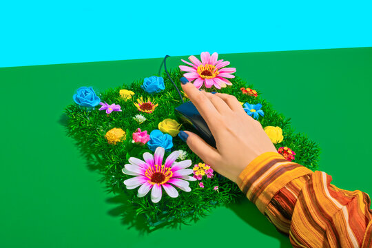 Hand of businesswoman touching computer mouse kept on flowerbed