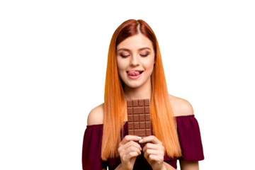 Young red-haired girl holding a chocolate bar isolated on yellow background