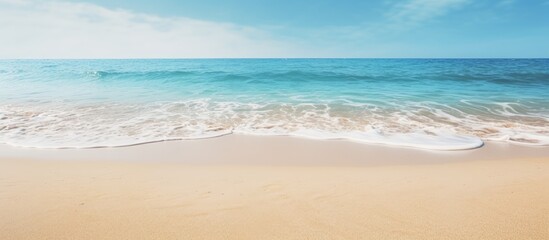 Fototapeta na wymiar Tranquil Seaside Scene: Sun-Kissed Sandy Beach Embraces Gentle Wave Under Clear Skies