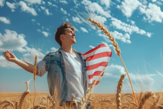 Young man with American flag in wheat field