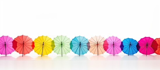 Vibrant Array of Colorful Cocktail Umbrellas Lined Up on White Background