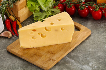 Swiss Maasdam cheese triangle over board