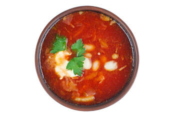 Clay bowl with Ukrainian borscht (beetroot soup) isolated on white background.