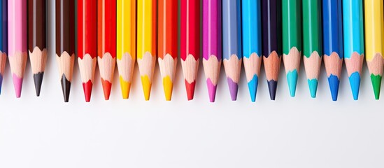 Vibrant Colored Pencils Neatly Aligned in a Rainbow Spectrum Order on White Background - obrazy, fototapety, plakaty