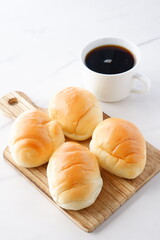 焼きたてのバターロールと淹れたてのコーヒーが用意された朝食のテーブル
