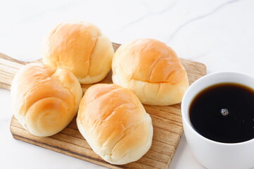 焼きたてのバターロールと淹れたてのコーヒーが用意された朝食のテーブル
