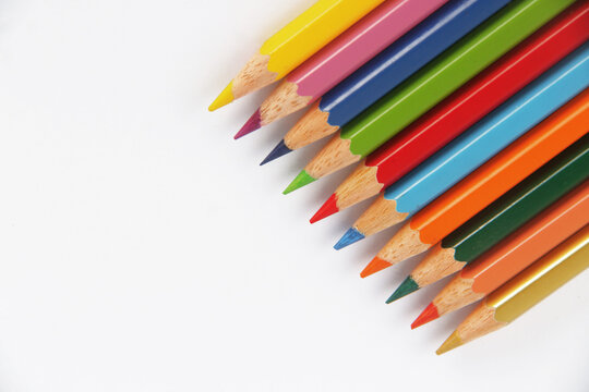 Neatly arranged colored pencils against a white background