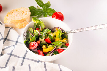 Fresh salad with tomato, cucumber, bel pepper in white bowl,