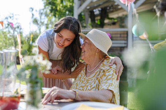 Granddaughter and grandmother reunite after at garden party.