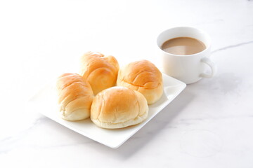 焼きたてのバターロールと淹れたてのカフェ・オ・レが用意された朝食のテーブル
