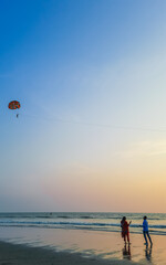 Parasailing extreme sports on beach in blue sky background. Man is parasailing in the blue sky. Paragliding in the clear sky above the sea.