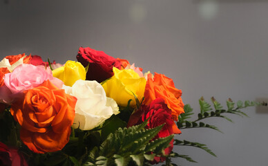 A bouquet of multicolored roses on a dark background, with a slight vignetting.