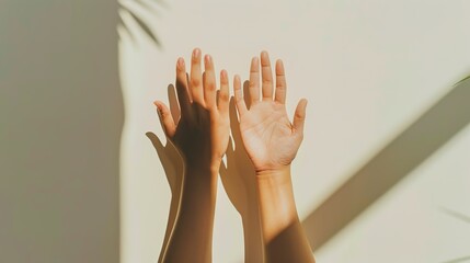 sunlit hands against white wall