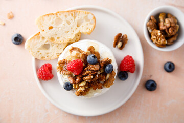 Baked camembert cheese with nuts and berries