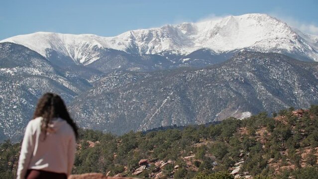 Woman Standing And Looking At Pikes Peak From Garden Of The God In Colorado Springs, Colorado. medium shot, back view