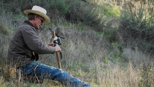 Cowboy Hunter Setting Up Wildlife Game Camera on Post