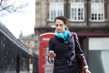 Woman on mobile phone outside a British Red Phonebox.