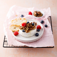 Baked camembert cheese with nuts and berries