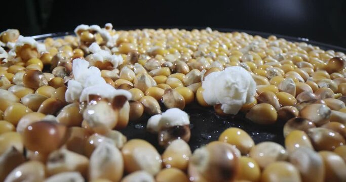 Appetizing popcorn is being prepared and corn kernels are popping closeup macro 4k movie. Recipes concept