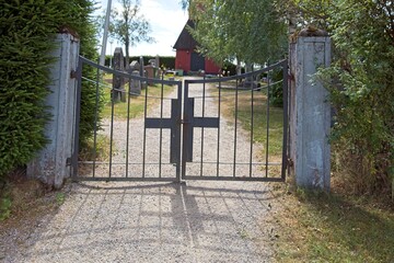 Old wrought iron gate with cross to cemetery.