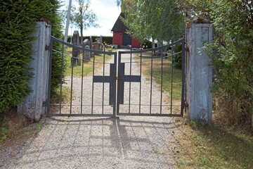 Obraz premium Old wrought iron gate with cross to cemetery.