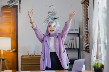 Young asian islamic women throwing up money at office desk, Businesswoman throwing money in the air.
