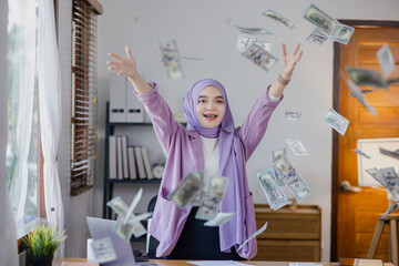 Young asian islamic women throwing up money at office desk, Businesswoman throwing money in the air.