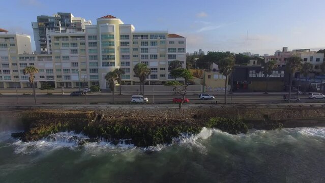 Aerial of Red Mustang Driving in Malecon Coastline in Santo Domingo City