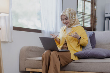 Young asian islamic women with laptop computer in the living room.