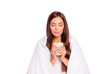 Autumn melancholy. Portrait of young smiling lady wrapped in blanket, drinking coffee. Isolated over pink pastel background