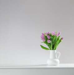 pink tulips in white jug on white background