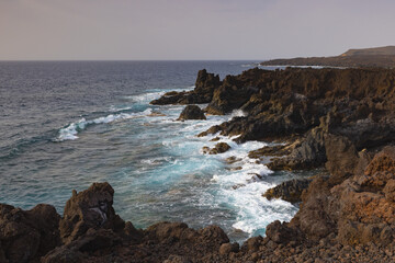 Fototapeta na wymiar Los Hervideros,rugged volcanic coastline known for waves crashing into sea caves & picturesque views.