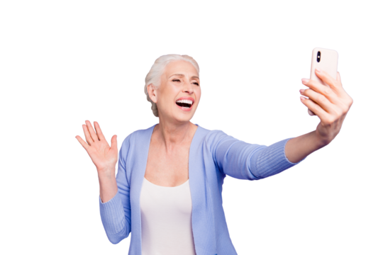 Grey haired old happy excited funny funky woman wearing casual, taking self picture, waving to cam, opened mouth. Isolated over violet purple background