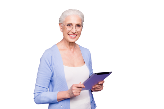 Grey haired old smiling business woman wearing glasses, reading browsing using holding tablet. Isolated over violet purple background