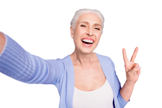 Self portrait of grey haired old nice beautiful cheerful smiling woman showing v-sign gesture. Isolated over violet purple background - Powered by Adobe