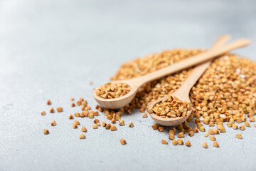 Green buckwheat in a wooden spoon on a wooden kitchen table.Superfood.Raw buckwheat porridge.Healthy vegan food concept, eco products, diet. Copy space.Organic food.weight loss and proper nutrition.