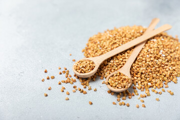 Green buckwheat in a wooden spoon on a wooden kitchen table.Superfood.Raw buckwheat porridge.Healthy vegan food concept, eco products, diet. Copy space.Organic food.weight loss and proper nutrition.
