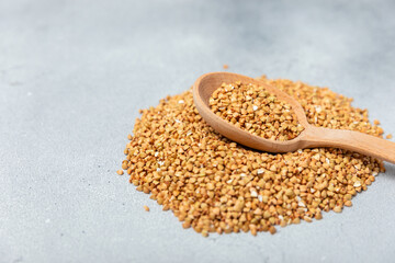 Green buckwheat in a wooden spoon on a wooden kitchen table.Superfood.Raw buckwheat porridge.Healthy vegan food concept, eco products, diet. Copy space.Organic food.weight loss and proper nutrition.