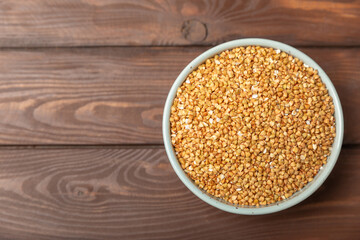 Green buckwheat in a bowl on a wooden kitchen table.Superfood.Raw buckwheat porridge.Healthy vegan food concept, eco products, diet. Copy space.Organic food.weight loss and proper nutrition.